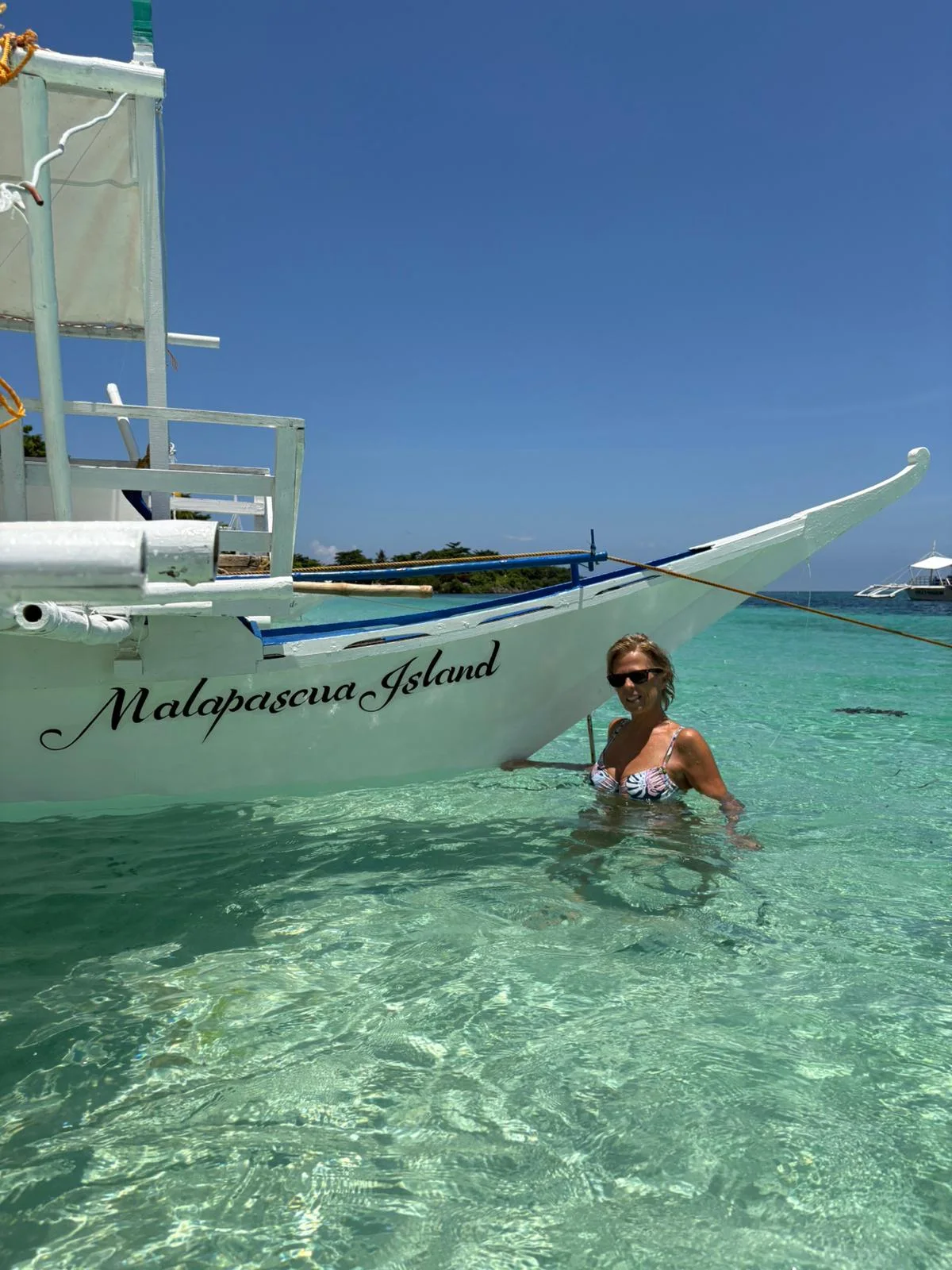 Gloria en el agua junto a una embarcación en Malapascua